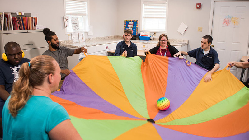 Indoor photo of a group playing with parachute Indoor photo of a group playing with parachute